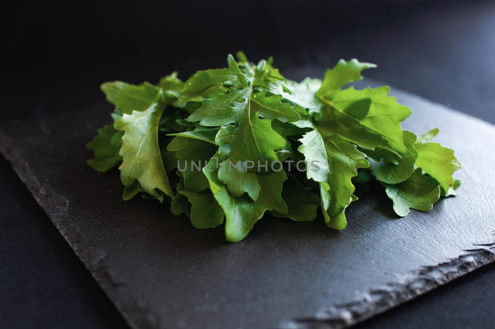 fresh arugula lying on a black board