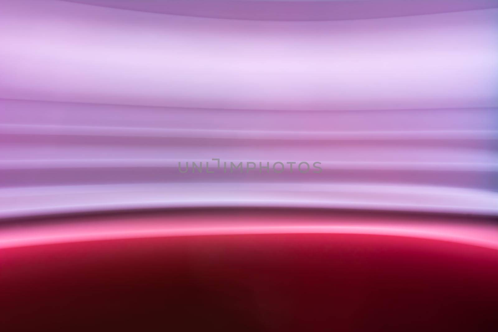 Blurred photo with colorful horizontal lines in pink, lilac, purple. Abstract backdrop.