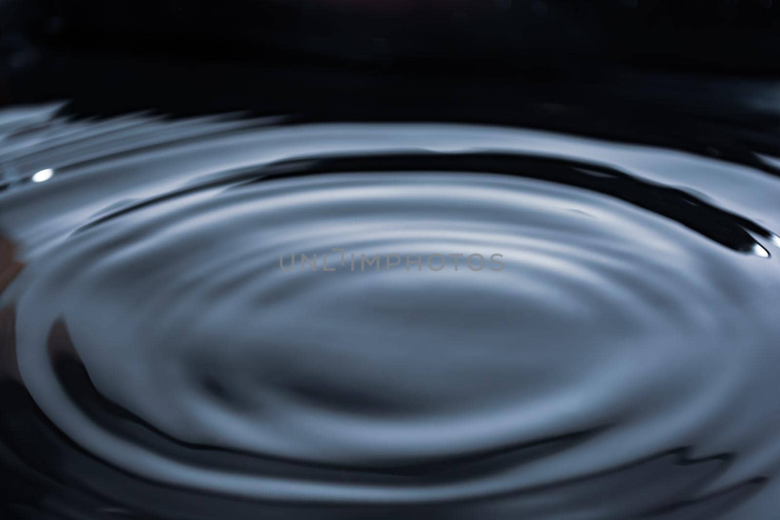 Circles on dark water. Shiny surface. Liquid background banner. View from above. Provides space for text.