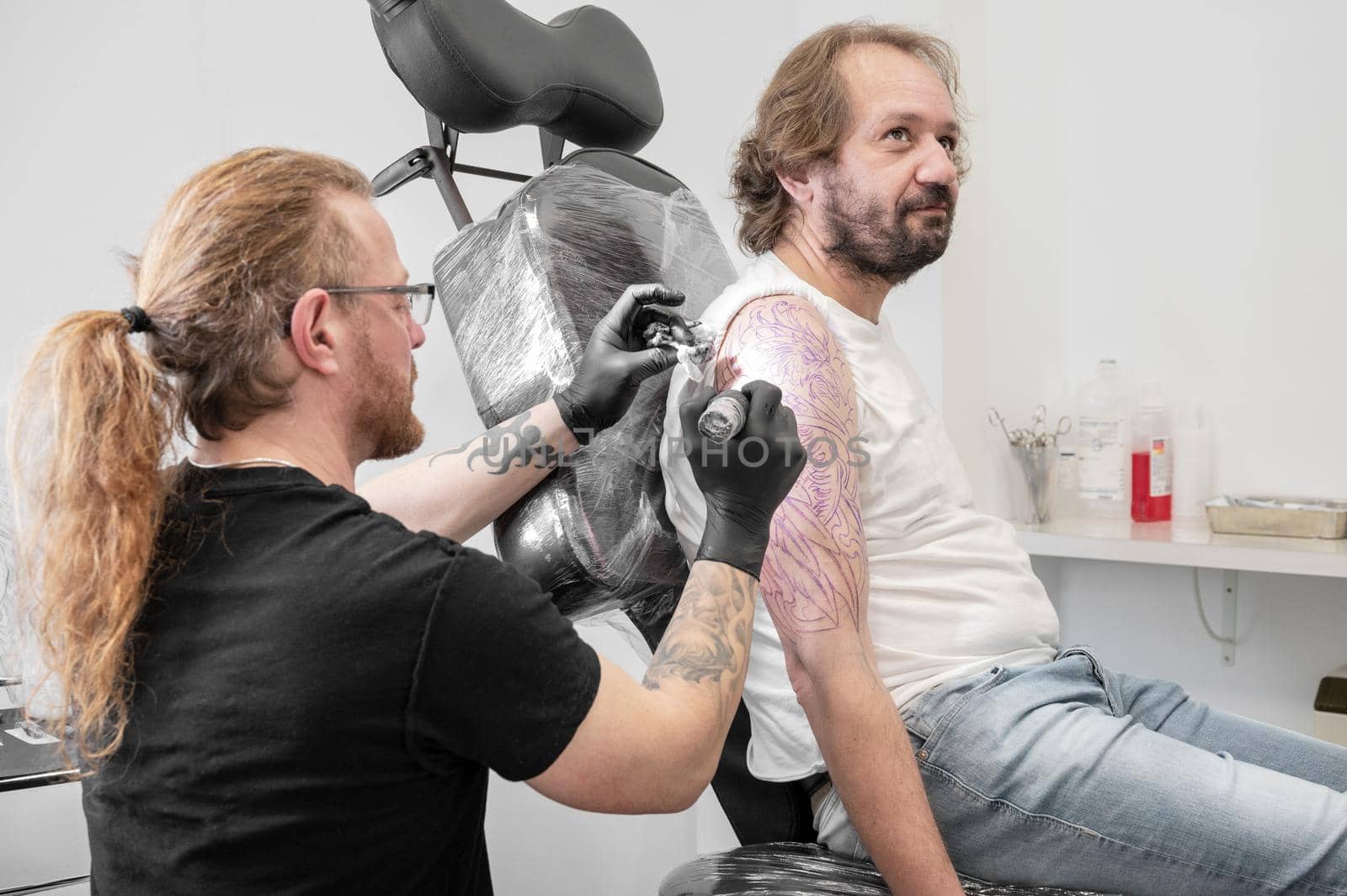 Tattoo artist making tattoo at the studio by HERRAEZ