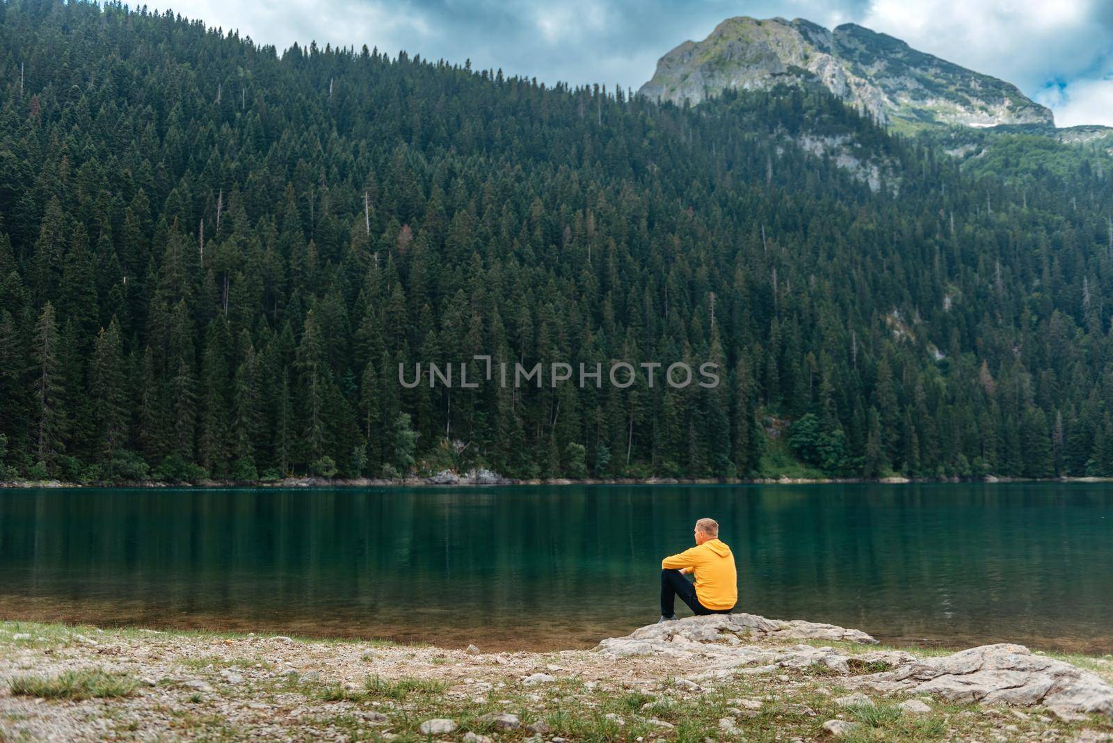 Traveler Man relaxing meditation with serene view mountains and lake landscape Travel Lifestyle hiking concept summer vacations outdoor