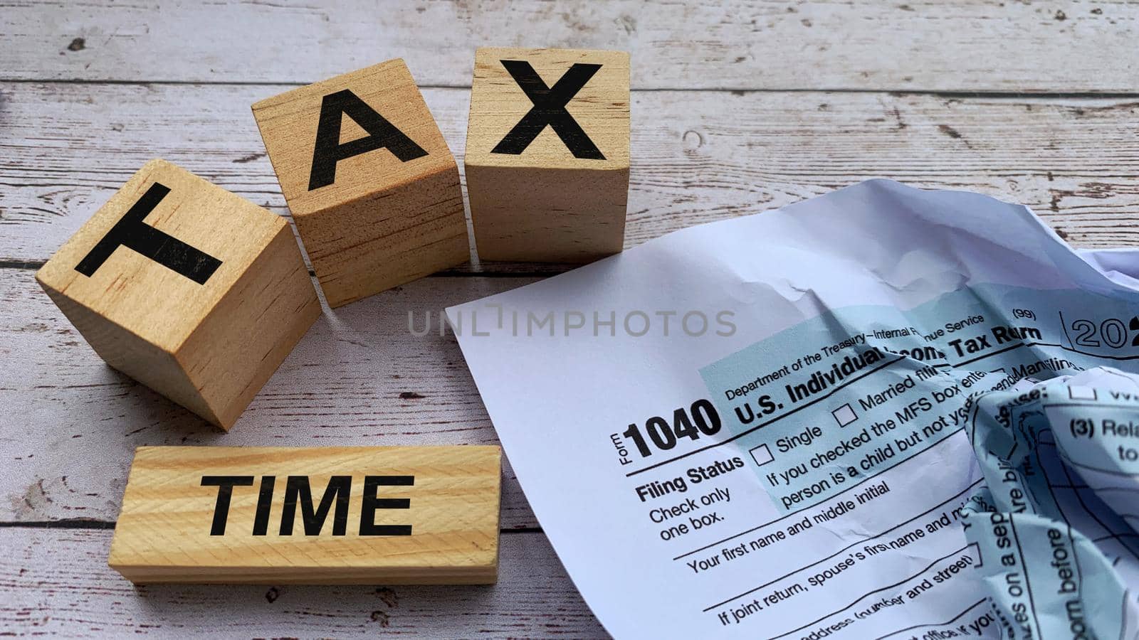 Tax time labeled on wooden blocks with tax form background.