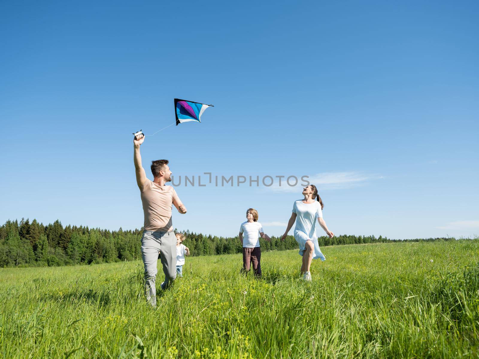 Family running through field with fly by ALotOfPeople