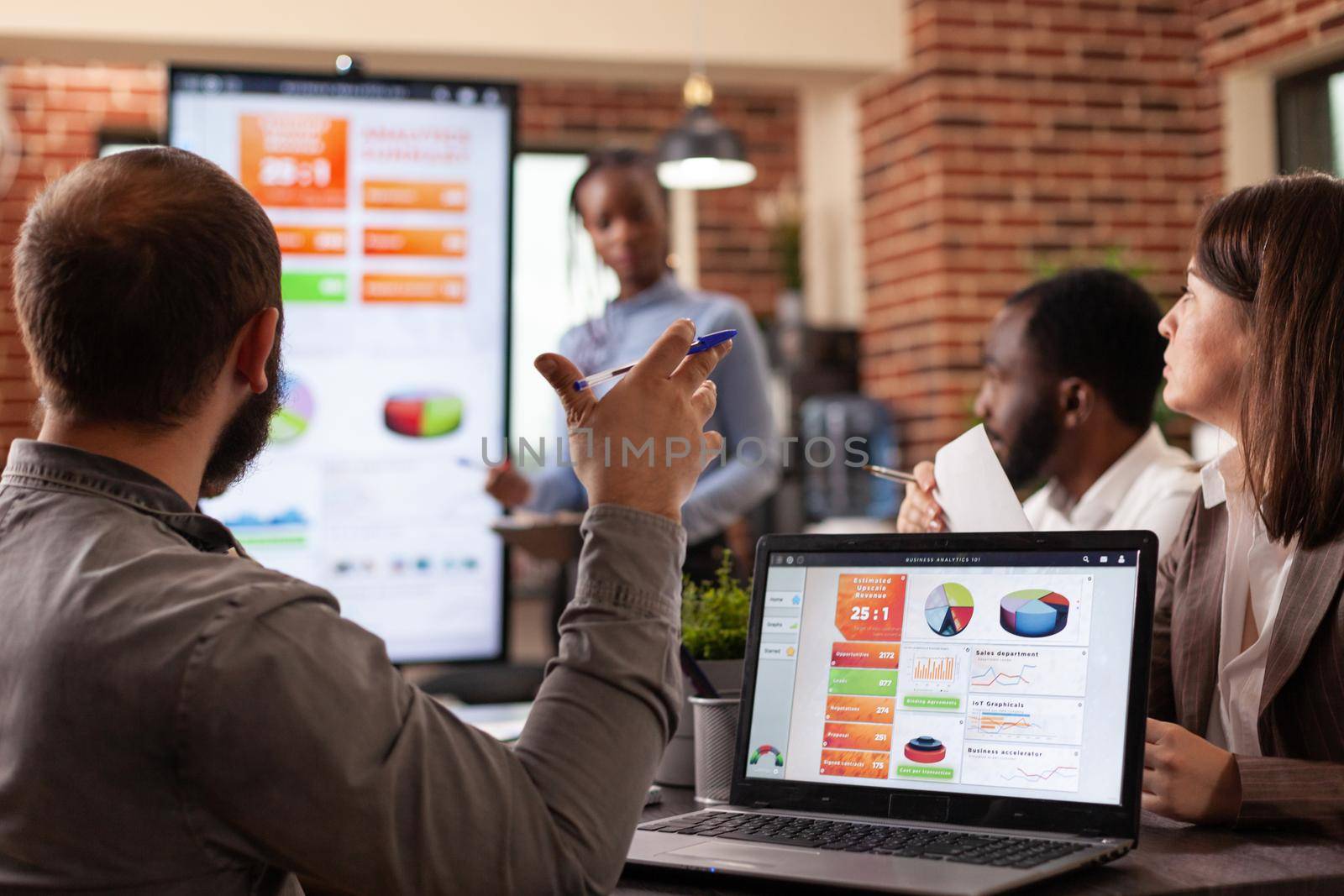 Businessman analyzing management statistics on laptop computer working at business presentation during business meeting in startup office. Diverse businesspeople discussing collaboration project