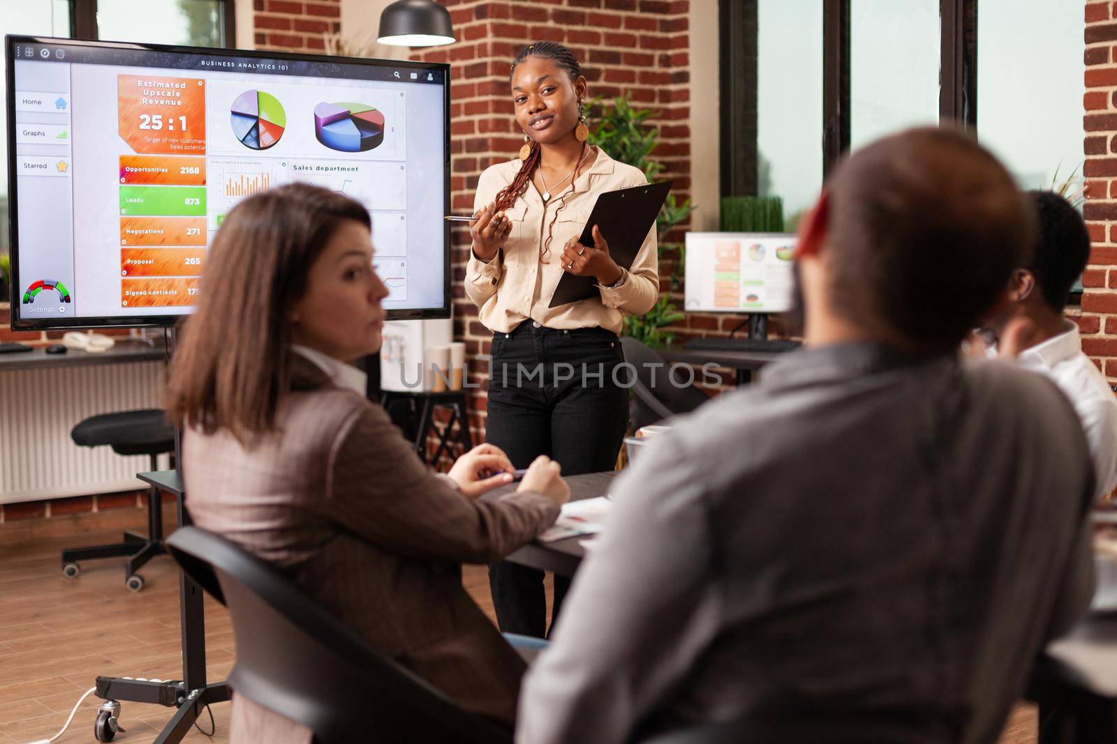 African american entrepreneur showing management presentation explaining company strategy planning business partnership working in startup office. Diverse team brainstorming project ideas