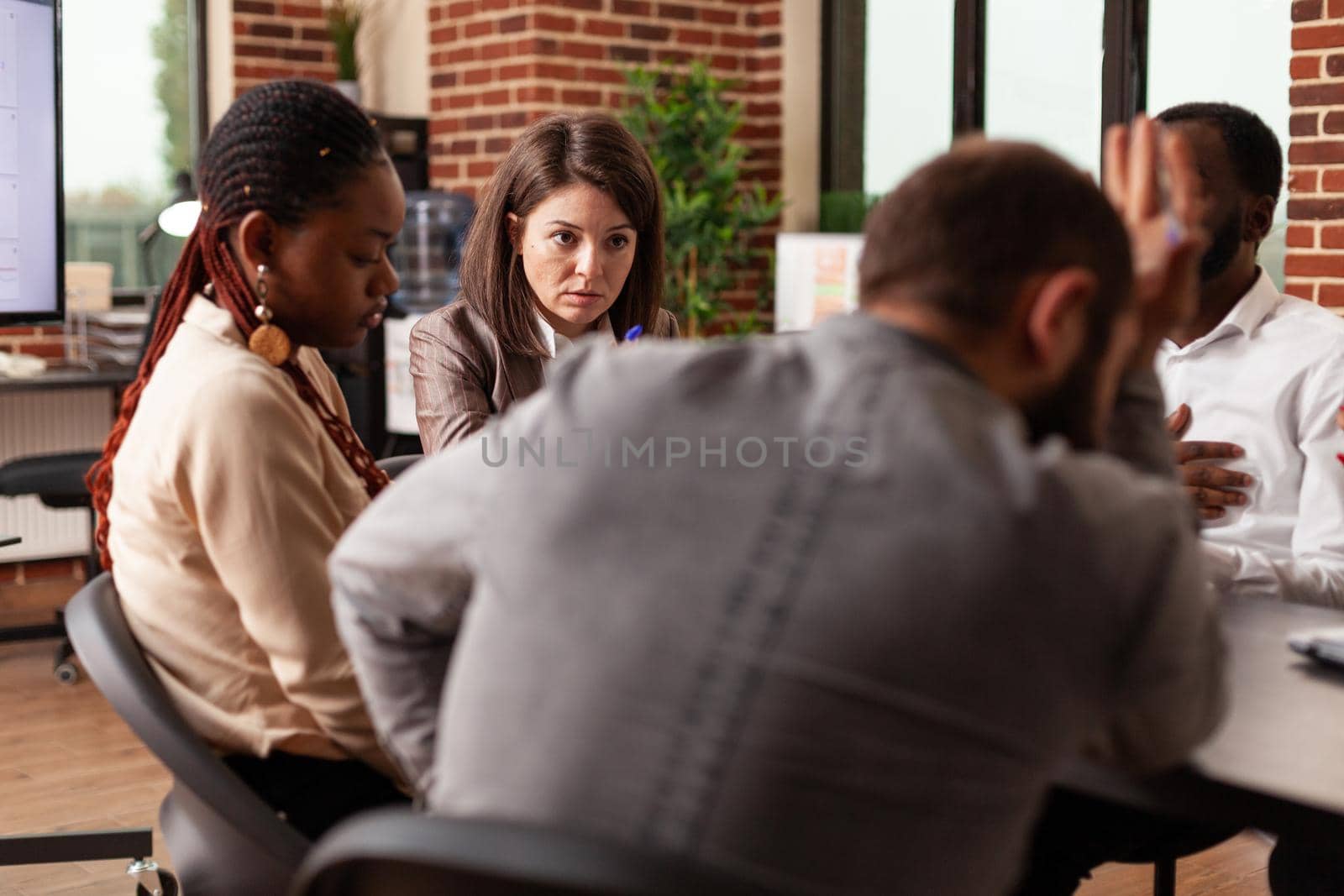 Diverse businessteam developing company project discussing management strategy during business meeting in startup office. Entrepreneurs analyzing financial graph, brainstorming ideas