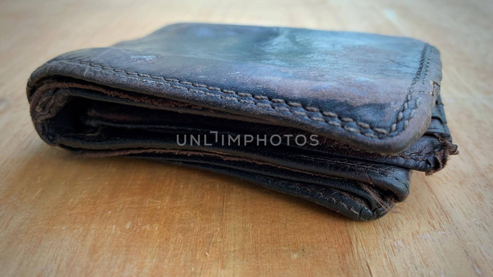 Old wallet on the wooden table. Conceptual