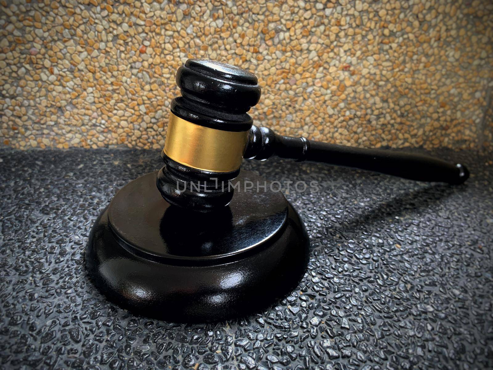 Close up of judge gavel on black and brown marble background.