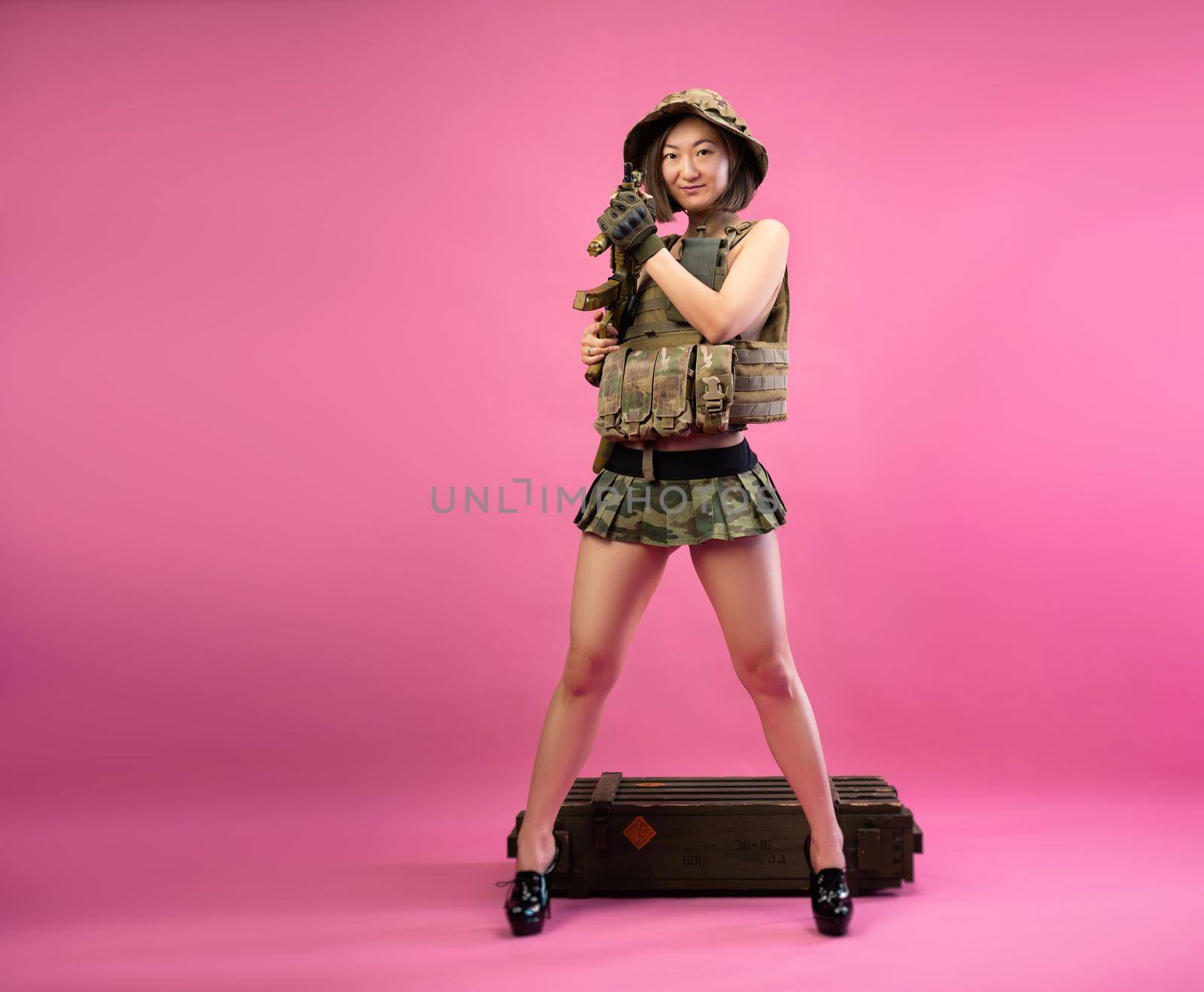 sexy Asian woman in military clothes with an automatic rifle in her hands while serving in the army by Rotozey