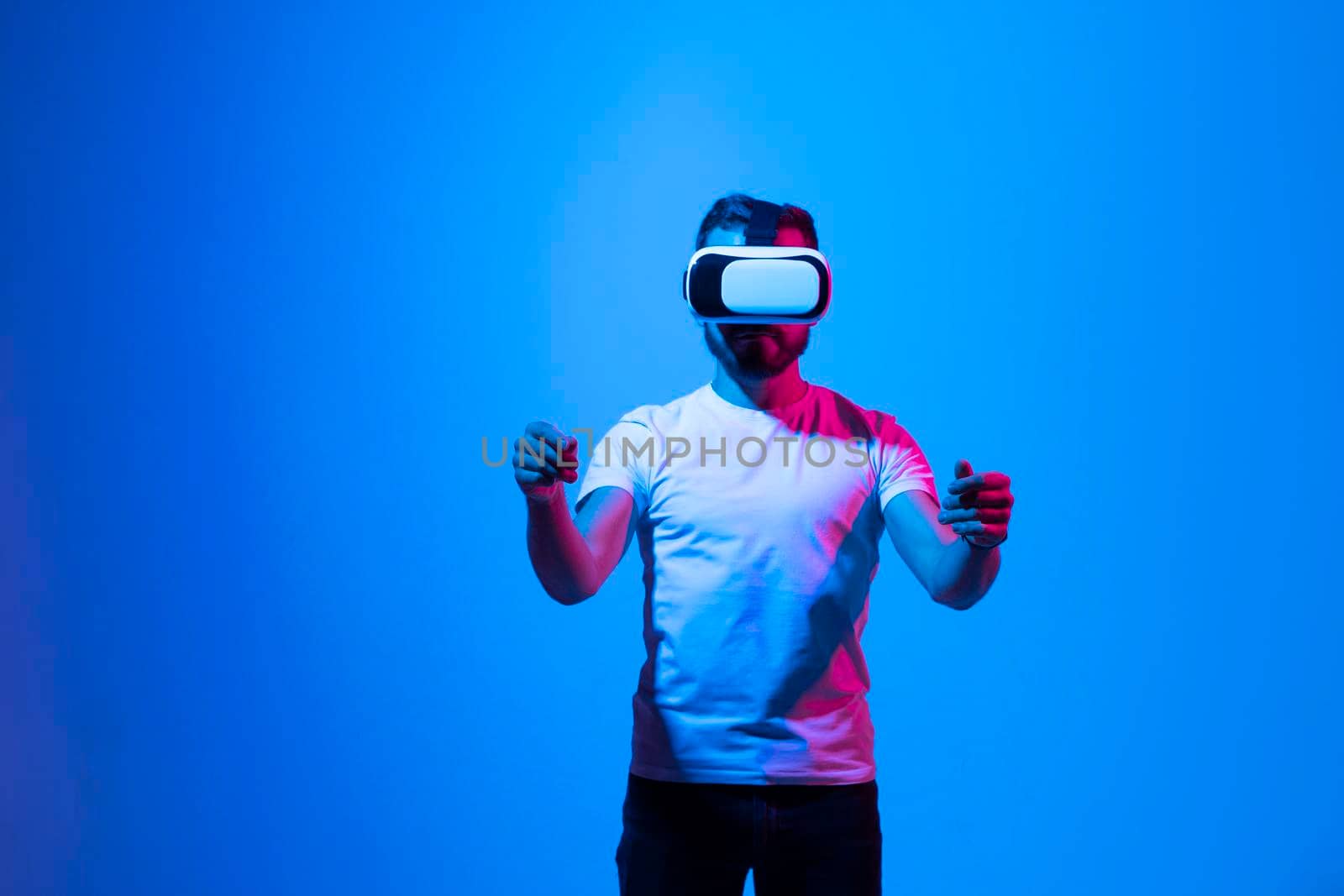 Man use a VR headset and stands as he hold something in virtual space. Future technology, online game, virtual reality, entertainment, study, 3D simulation and virtual world