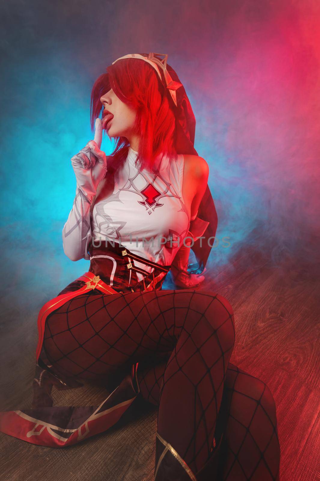 sexy young caucasian girl licks her finger in a cosplay costume, in fishnet stockings. sits on a wooden floor in smoke