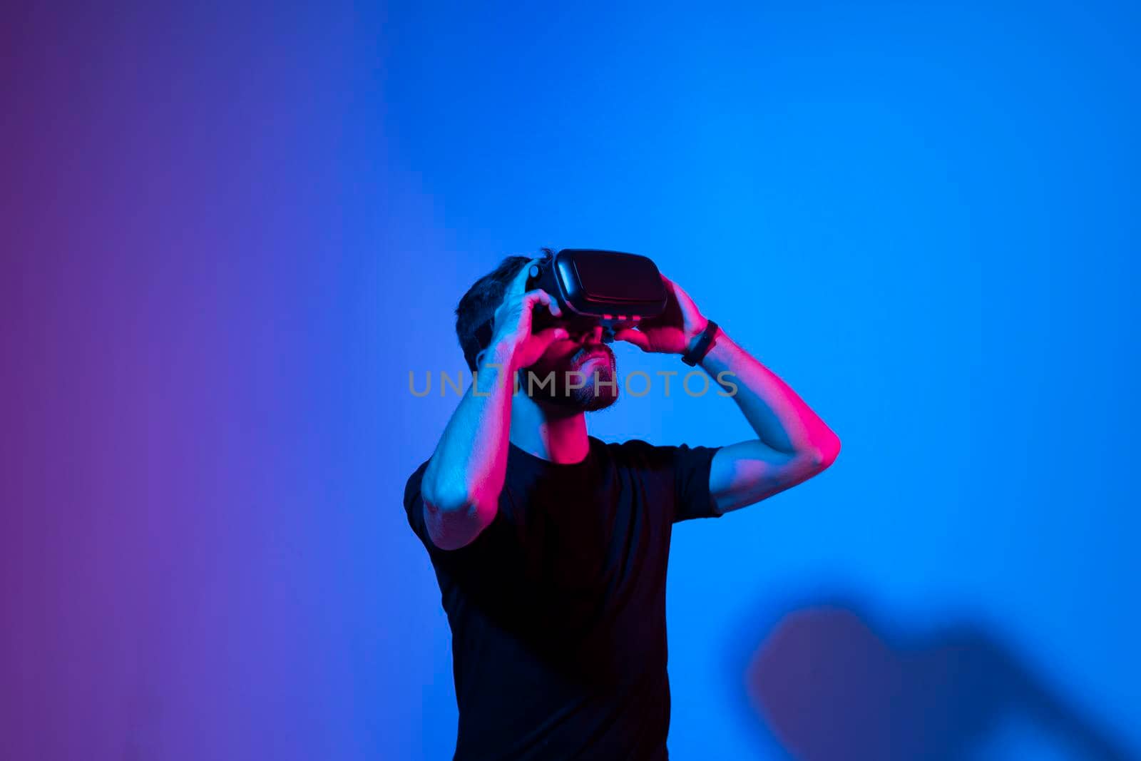 Metaverse and virtual reality concept. European bearded man in vr glasses exploring a virtual world while using a virtual reality headset. by vovsht