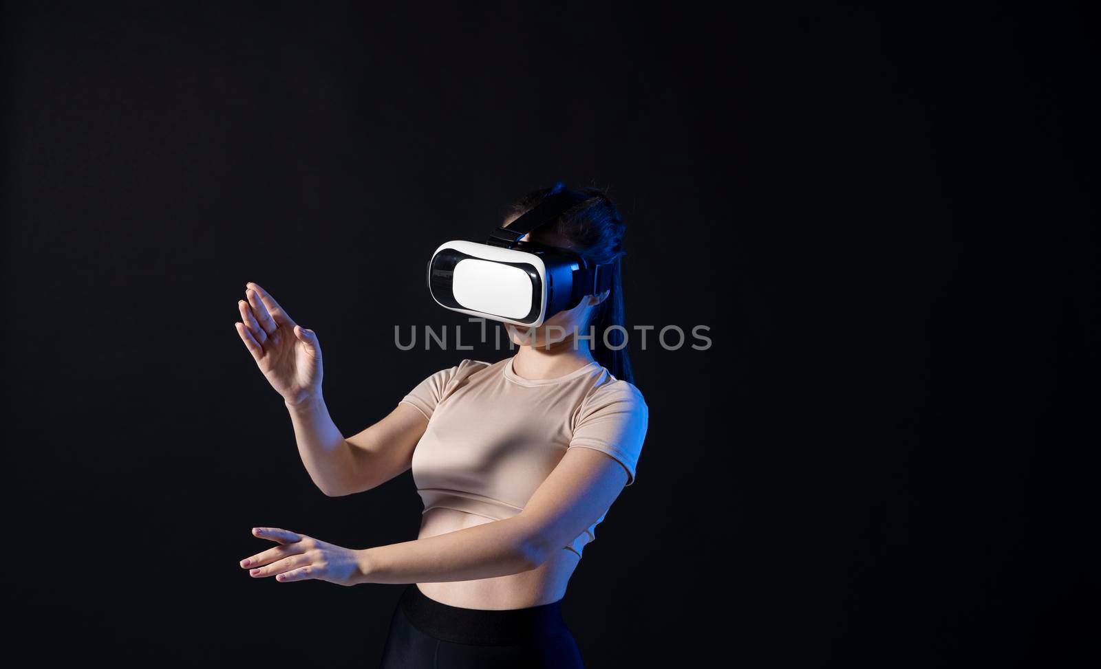 Woman architector using virtual reality glasses at workplace and working with a new project. Woman working in VR goggles in neon light. Designer working in VR studio. by vovsht