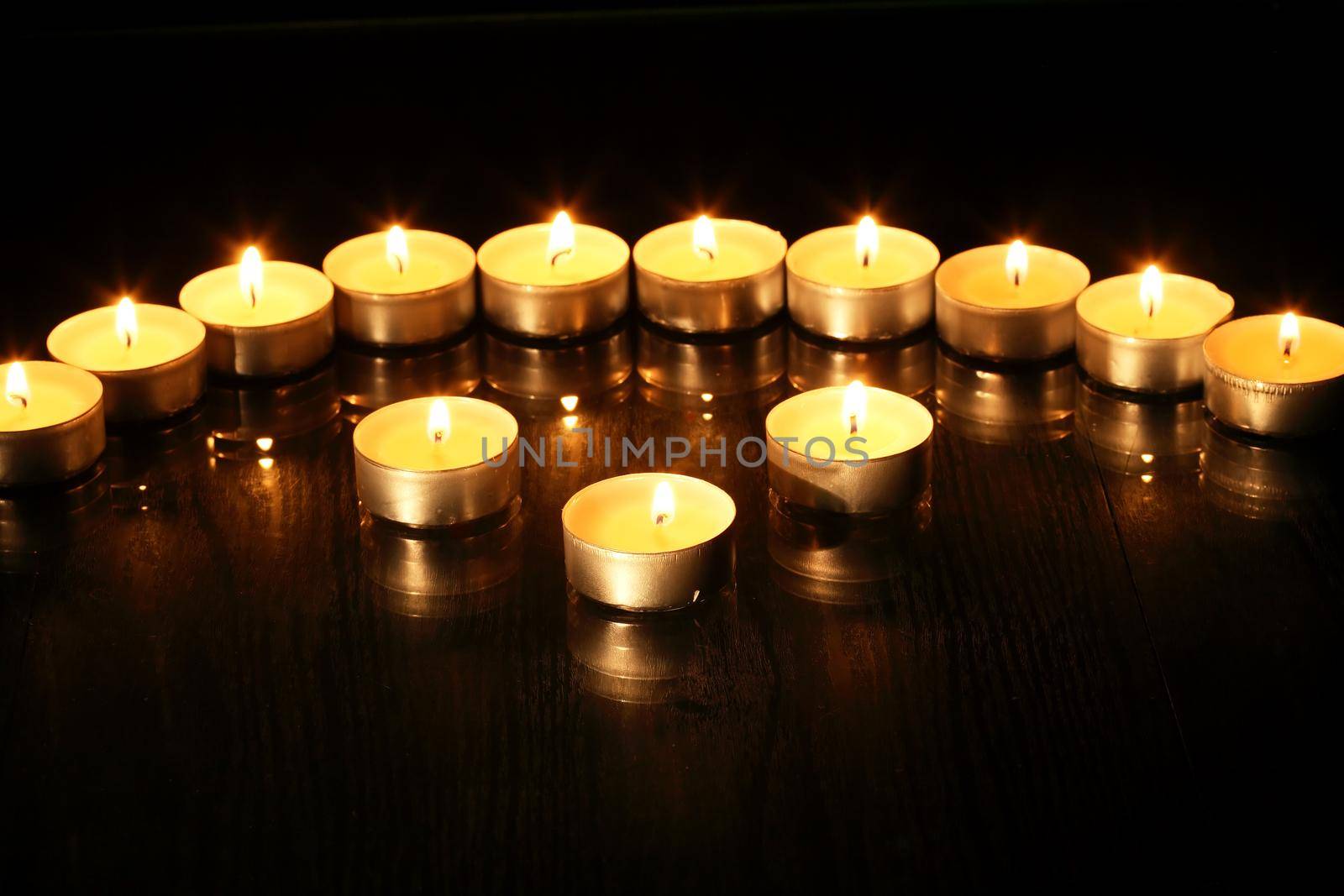 Set of flighting candles in a row against dark background