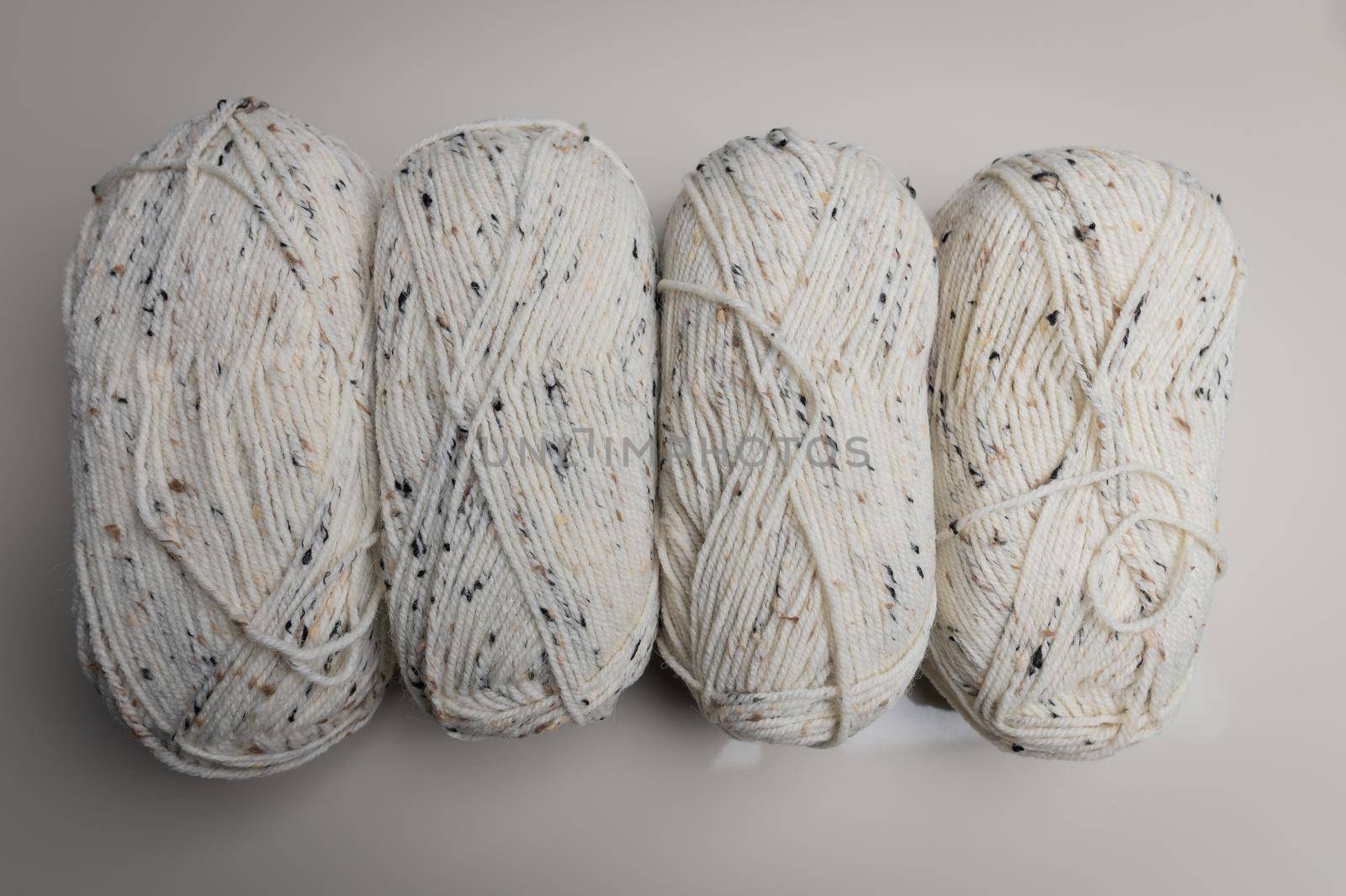 a row of colored yarn for knitting on a gray background