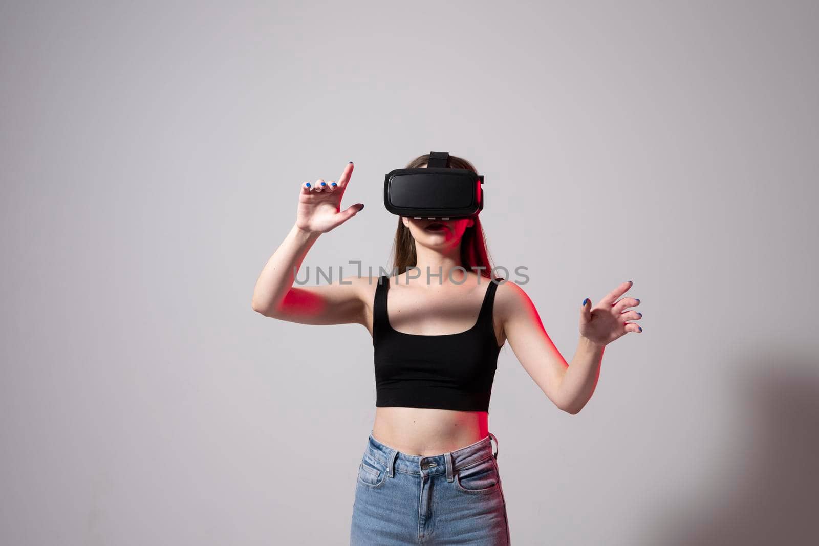 Designer, architect, developer or engineer woman wearing VR goggles and interacts with cyberspace using swipe and stretching gestures while working on a new perspective project. by vovsht