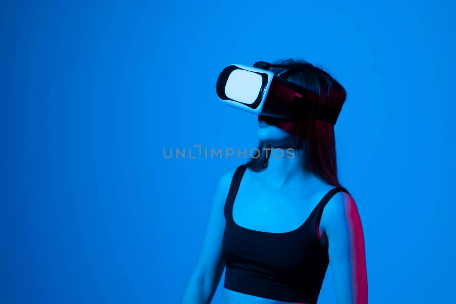 Amazed woman getting experience using glasses of virtual reality and exploring a virtual world. Girl spend shes time in metaverse while hanging out with a friends