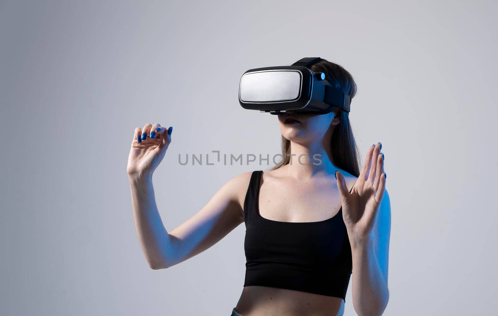 Amazed happy brunette girl in black t-shirt getting experience using VR headset glasses of virtual reality and exploring a new cyber worlds