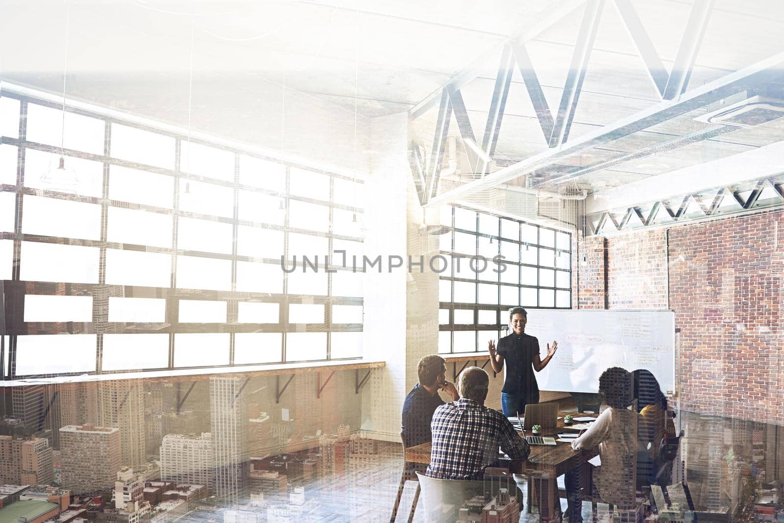 Multiple exposure shot of businesspeople having a meeting superimposed over a cityscape