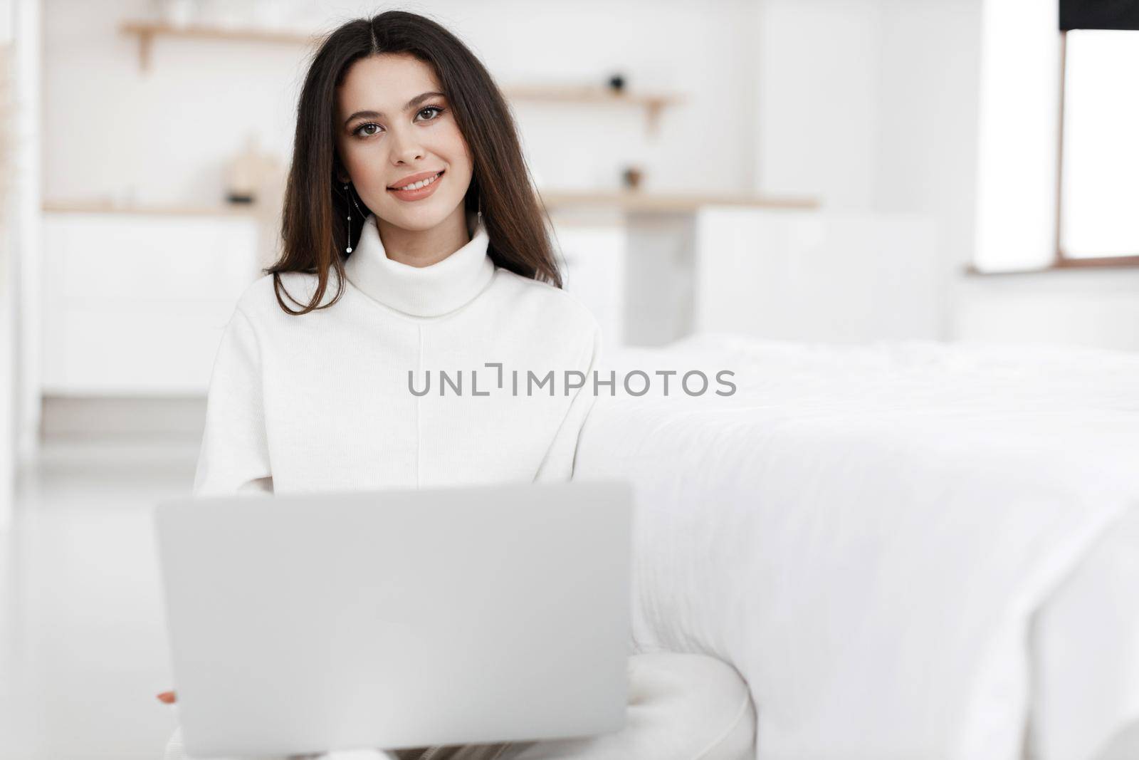 young cozy woman working in laptop by splash