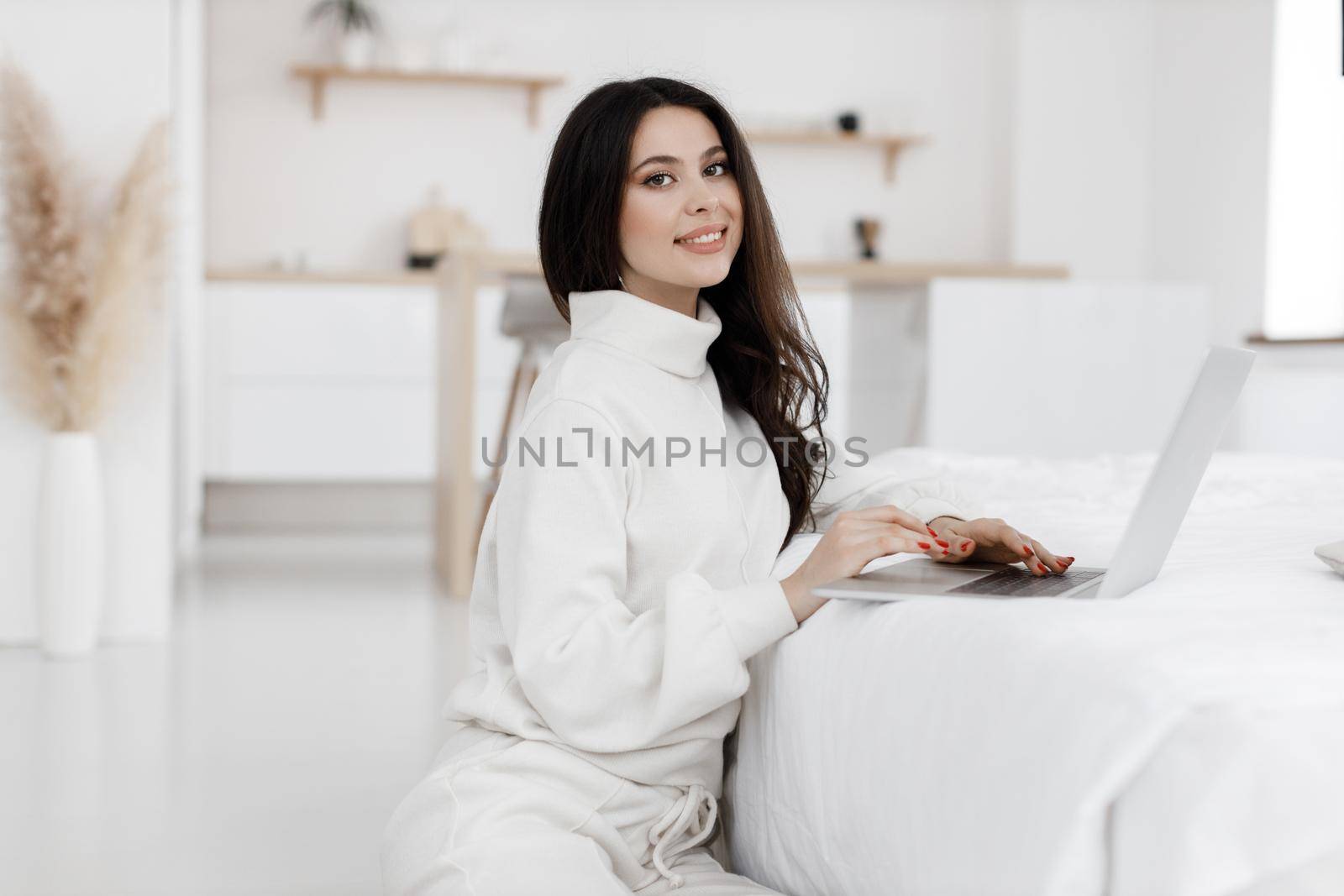 young cozy woman working in laptop by splash