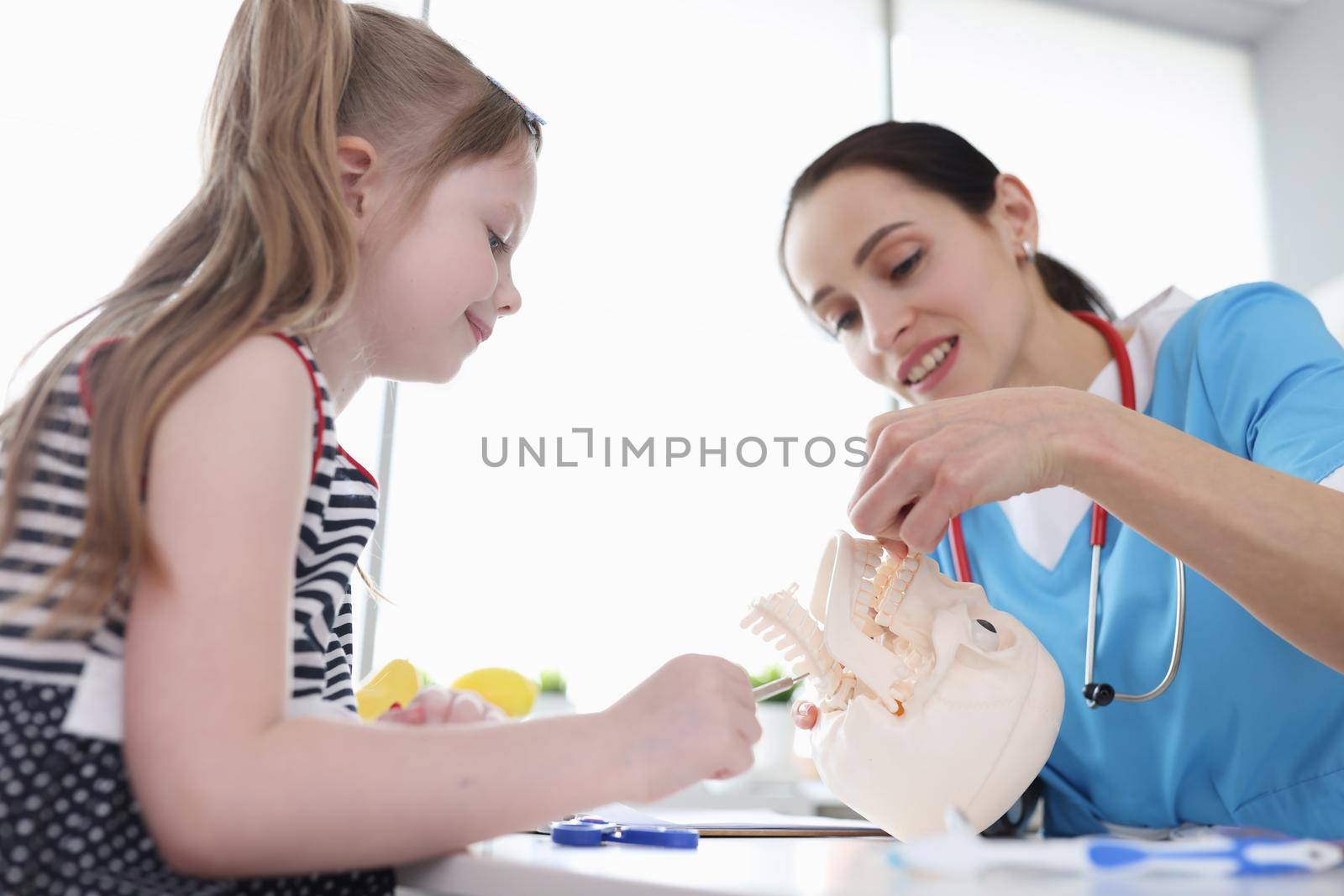 The doctor in the clinic teaches the child anatomy, close-up by kuprevich