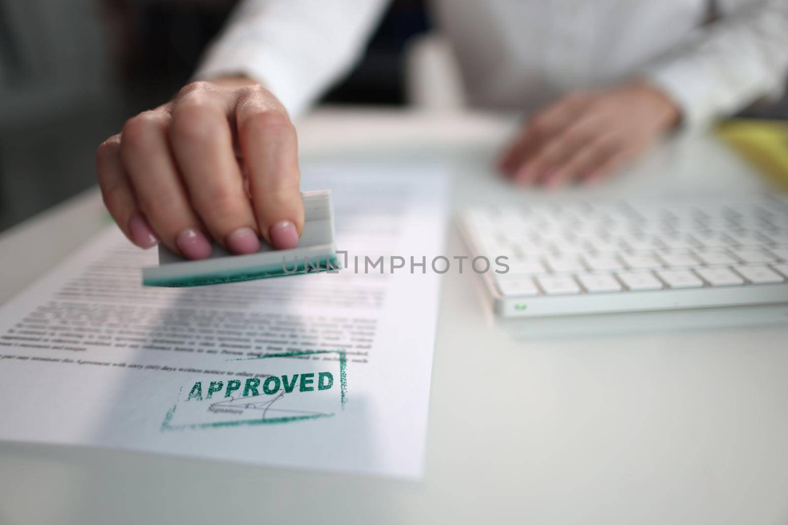 Green stamp approved on a document, close-up. The workplace of the chief, the solution of financial issues