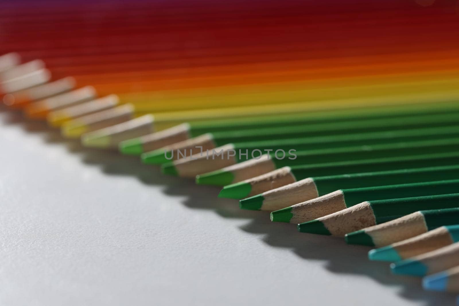 Colored pencils lie in a row on the table, blurry by kuprevich