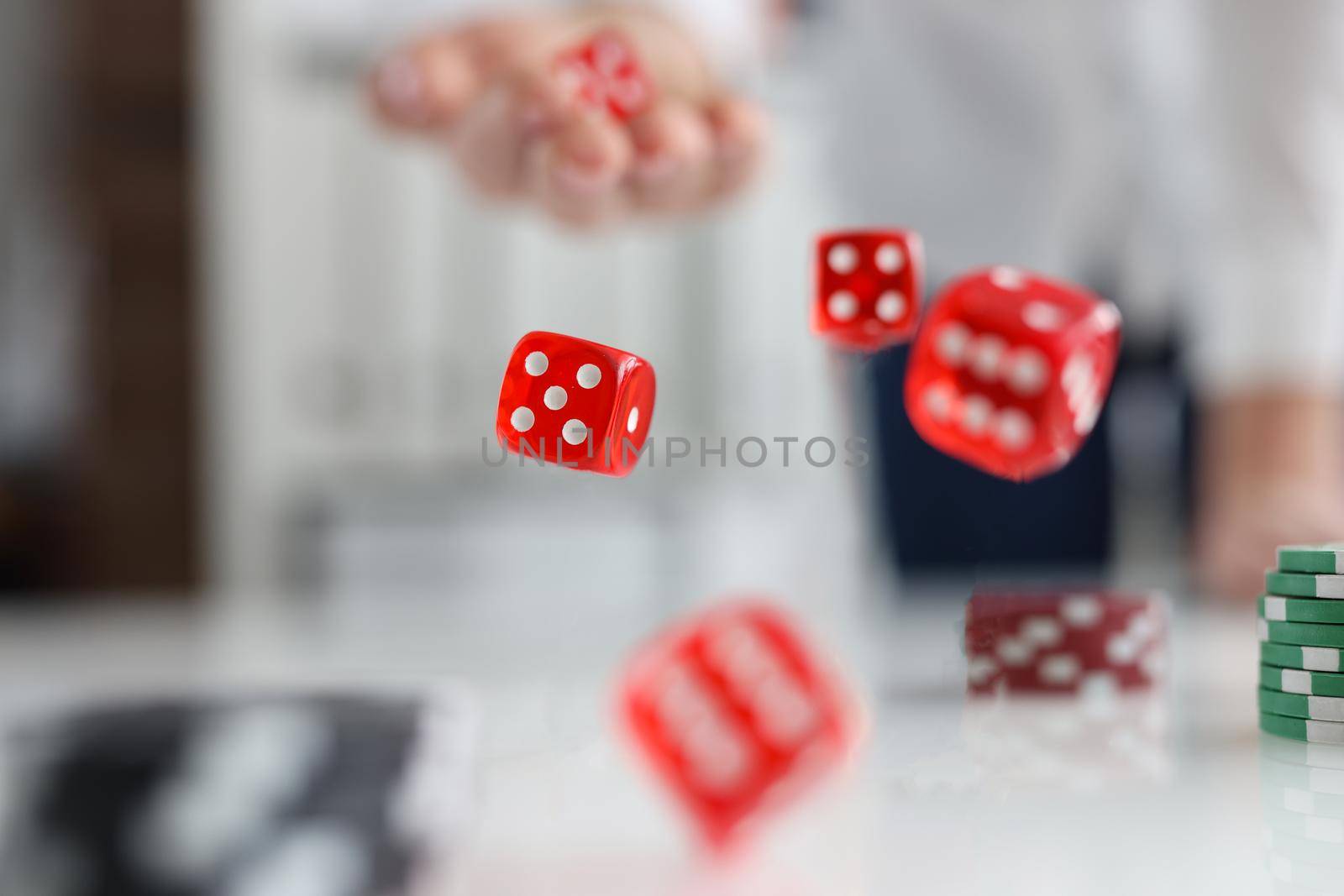 Red dice and green casino chips, close-up, blurry. Gambling, gambling addiction, participation in betting