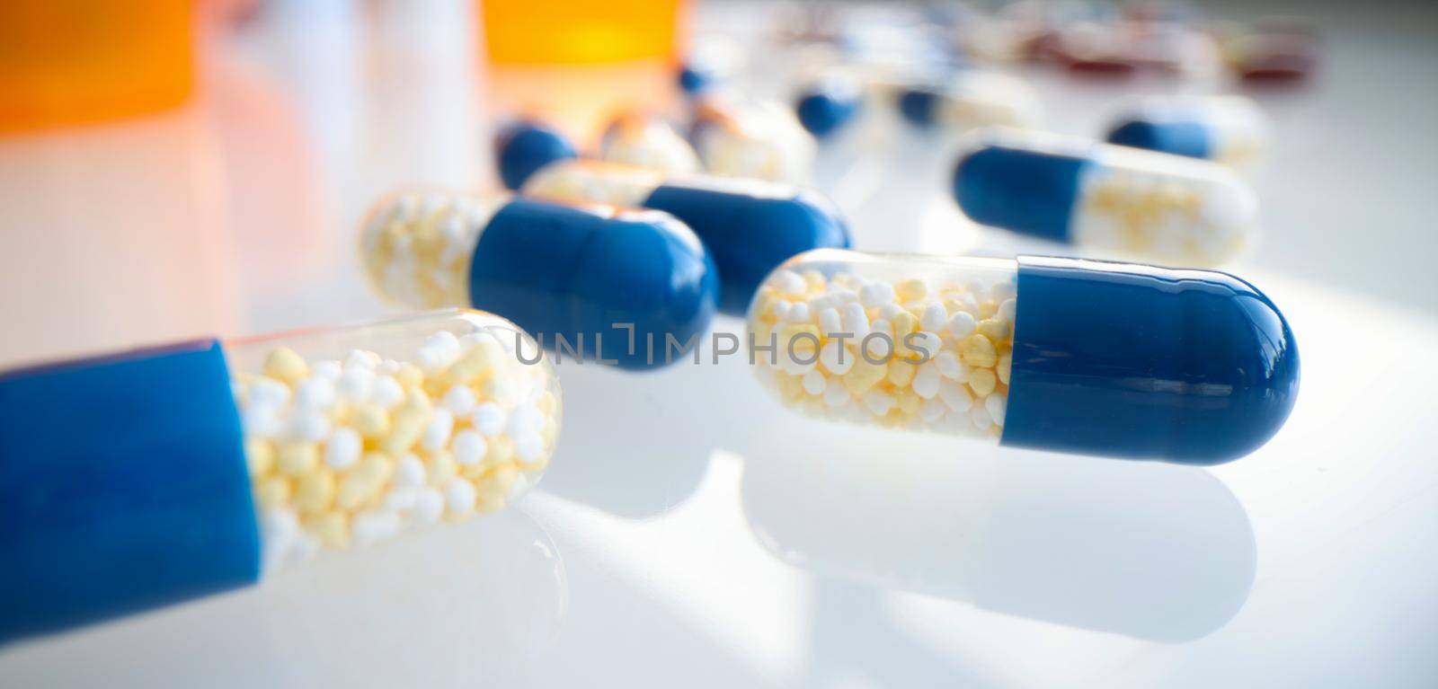 White blue capsules lie on the table, close-up, blurry. Medical product, pharmacology, dietary supplements
