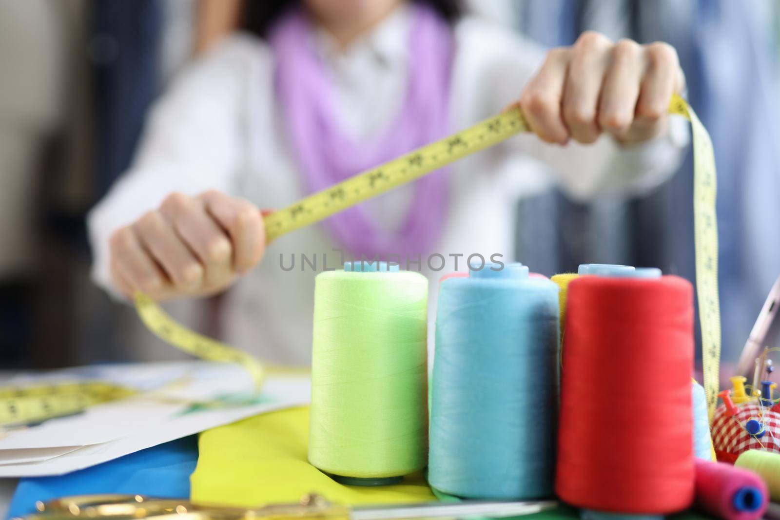 On the table of a seamstress are colored bobbins with threads by kuprevich