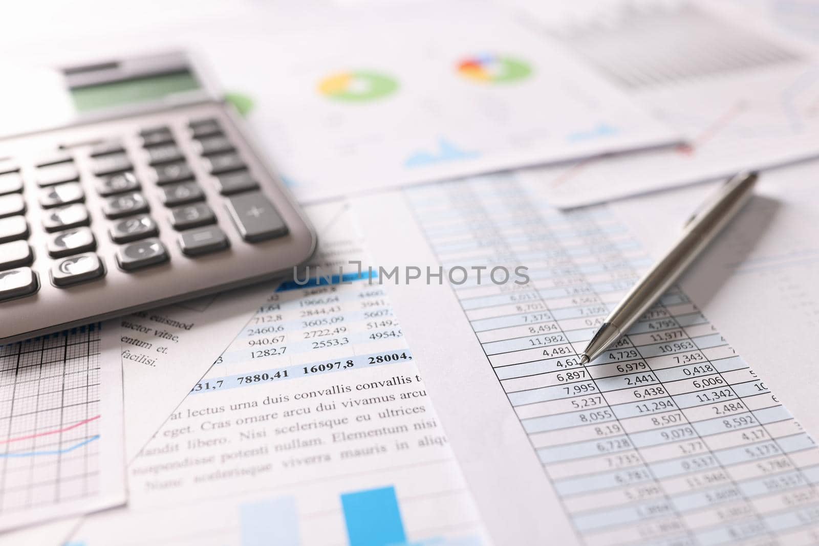 On the table is a calculator, pen and financial documents, close-up. Workplace of a financier, calculation of income and expenses