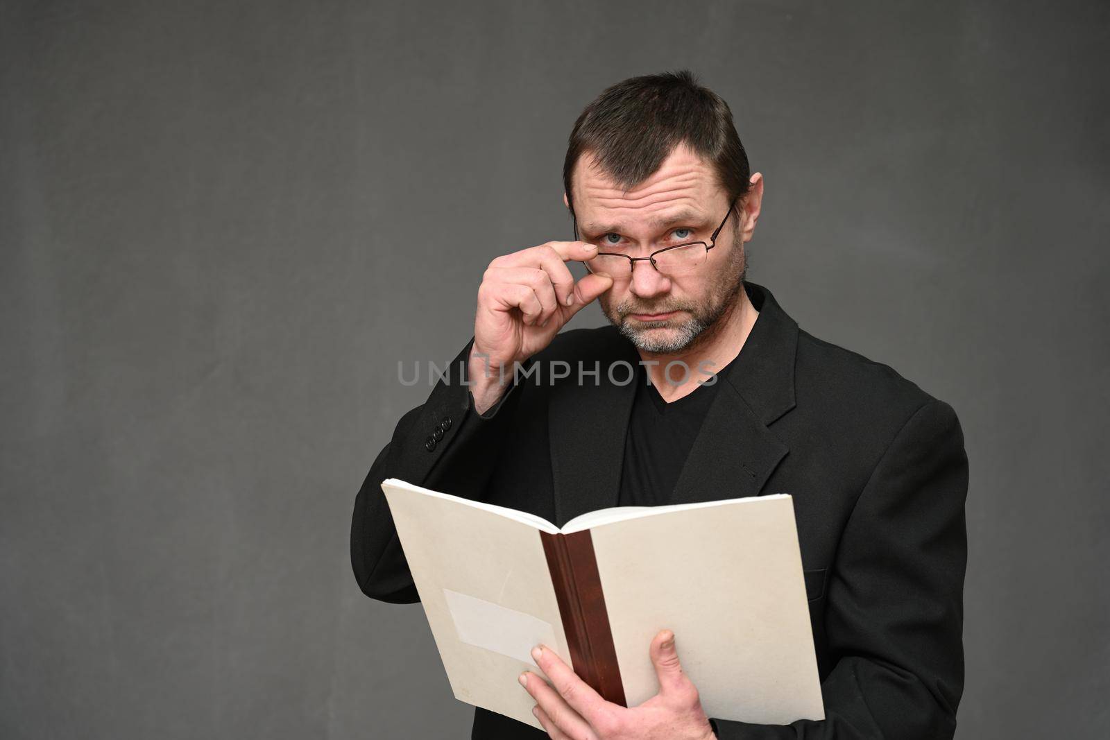 Portrait of a business man accountant in glasses with a book in his hands at work