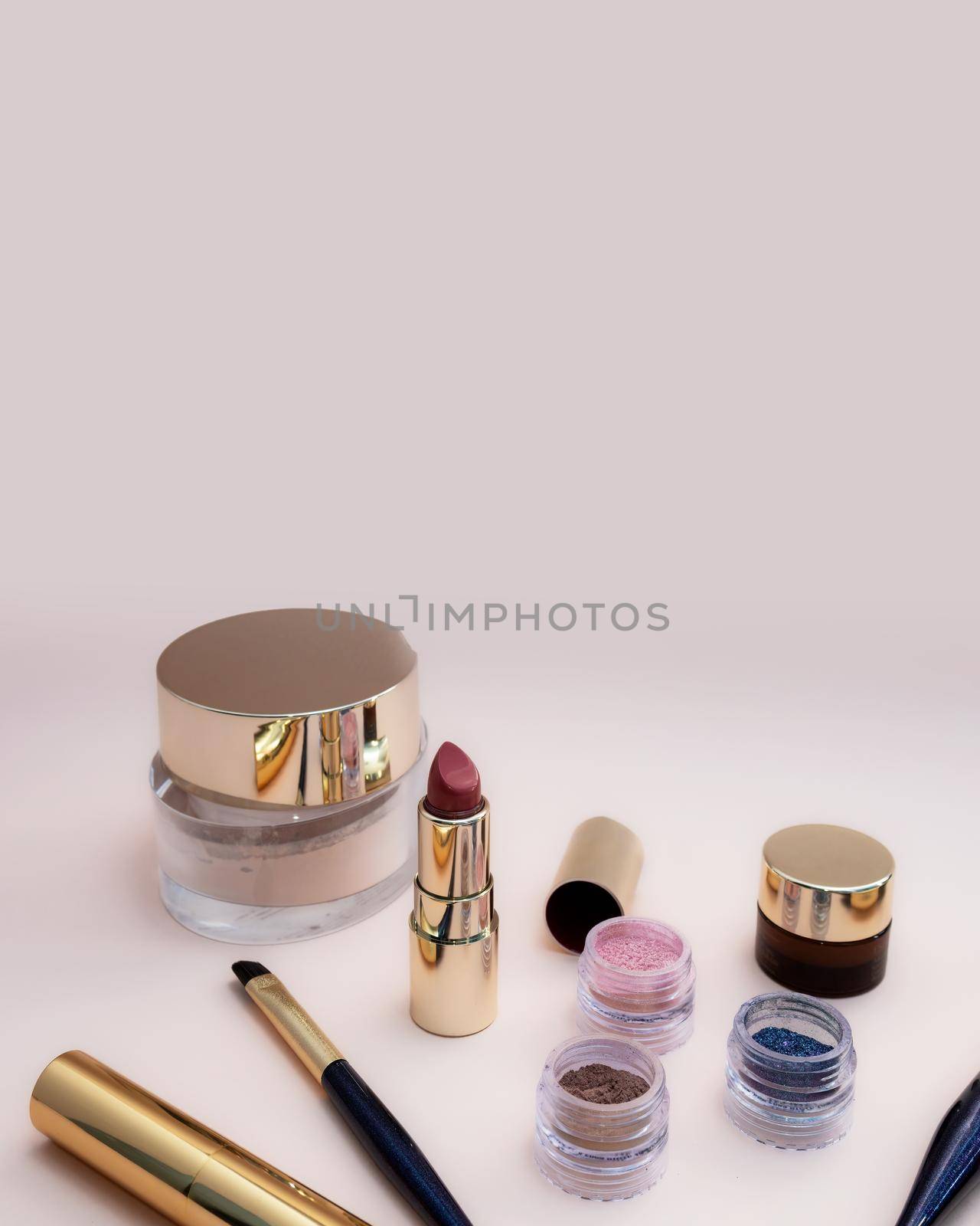 set of beauty cosmetics for female face and eye makeup on pink background. by Andre1ns