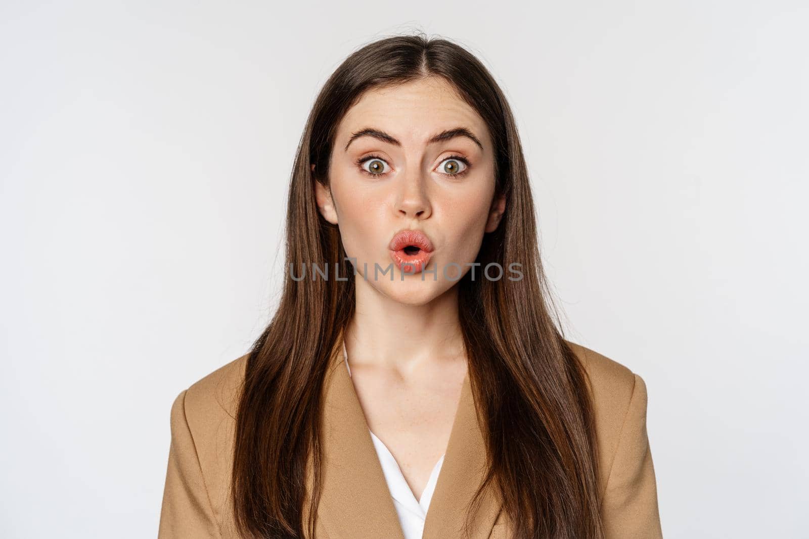 Close up portrait of surprised, amazed businesswoman, say wow, staring impressed at camera, fascinated face expression, white background.