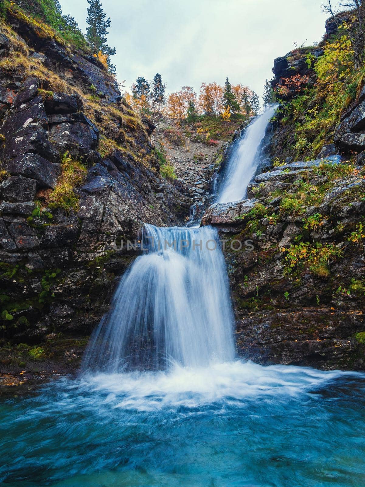 Beautiful mountain waterfall among rocks in polar summer in Khibiny Mountains. Kola Peninsula, Arctic, polar summer. photo