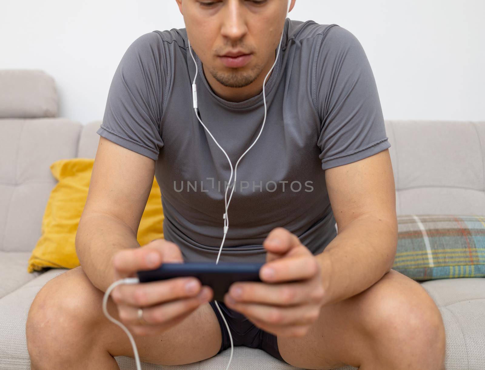 young man in headphones watching at mobile phone by Chechotkin