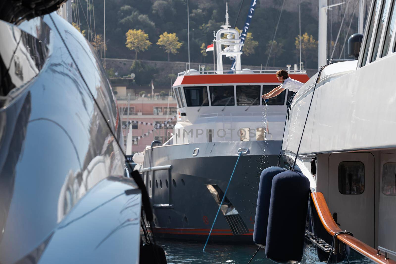 A lot of huge yachts are in port of Monaco at sunny day, Monte Carlo, mountain is on background, glossy board of the motor boat, megayachts are moored in marina, sun reflection on glossy board. High quality photo