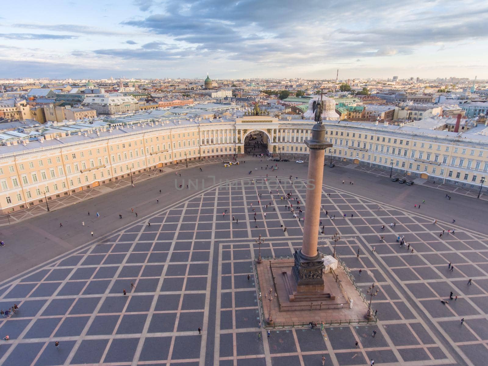 Aerial view of Palace Square and Alexander Column at sunset, a dome of Kazanskiy Cathedral on background, the Winter Palace, walking a little people. High quality photo