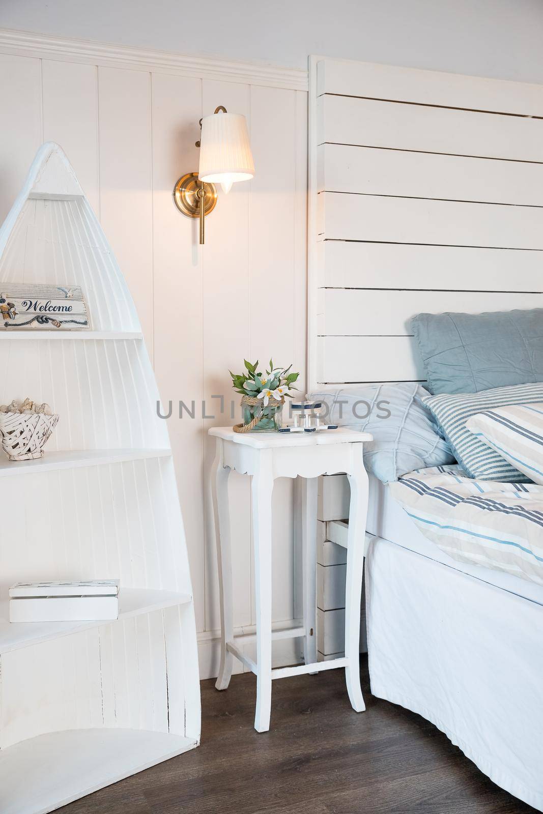 Flower on bedside table.Interior of modern bedroom with cozy bed