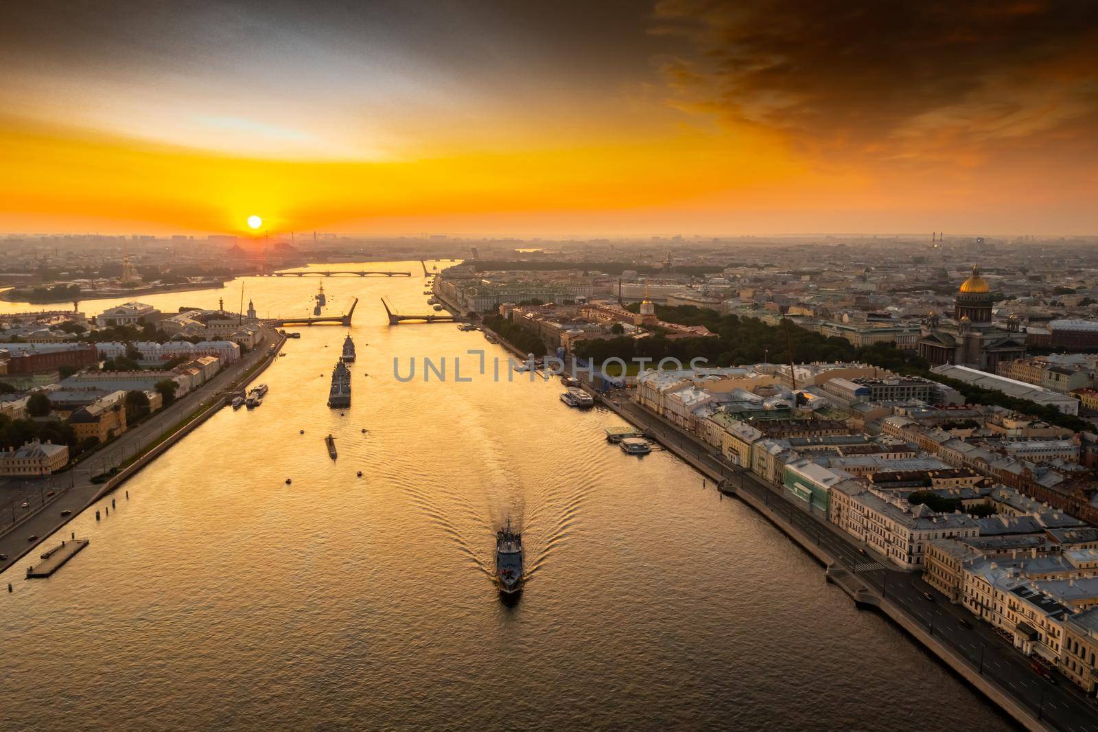 Aerial landscape with warships in the Neva River before the holiday of the Russian Navy at early morning, warships pass under a raised drawbridge, the latest cruisers among landmarks, Palace bridge. High quality photo