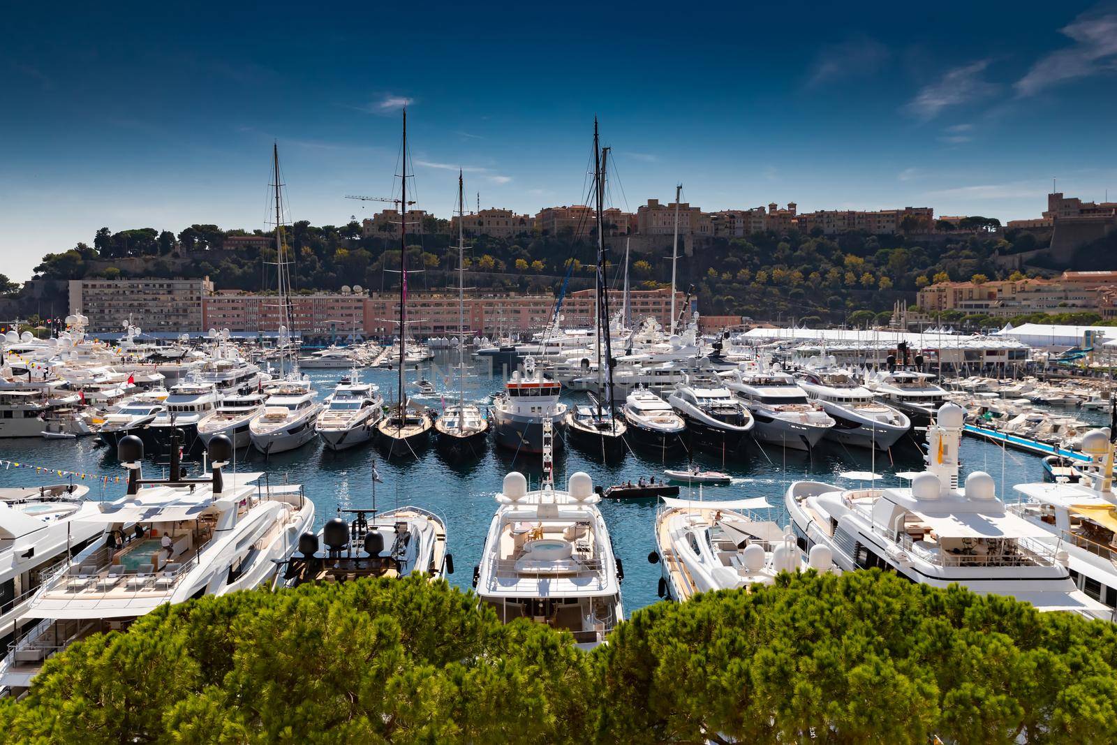 A lot of huge yachts are in port Hercule of Monaco at sunny day, Monte Carlo, many small boats are on background, interiors of motor boat, chilling zone of megayachts, sun reflections on glossy boards. High quality photo