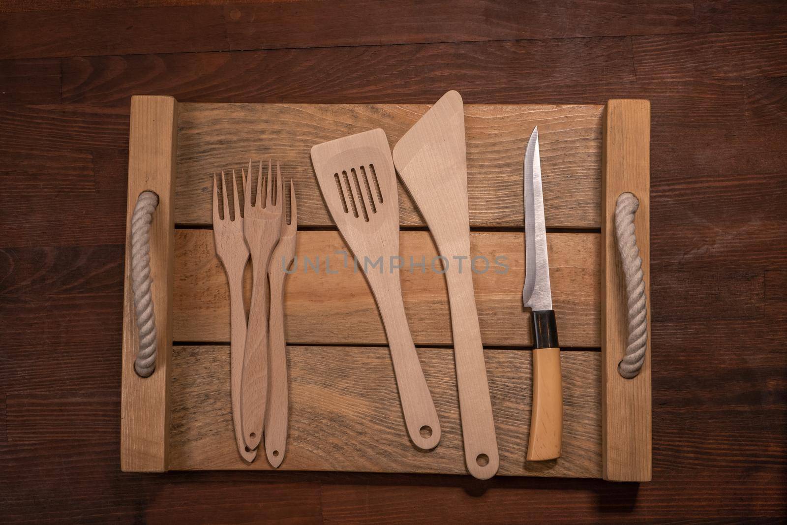 Wooden utensils set collection for your kitchen on wooden table horizontal banner layout. Top view on wooden table background.
