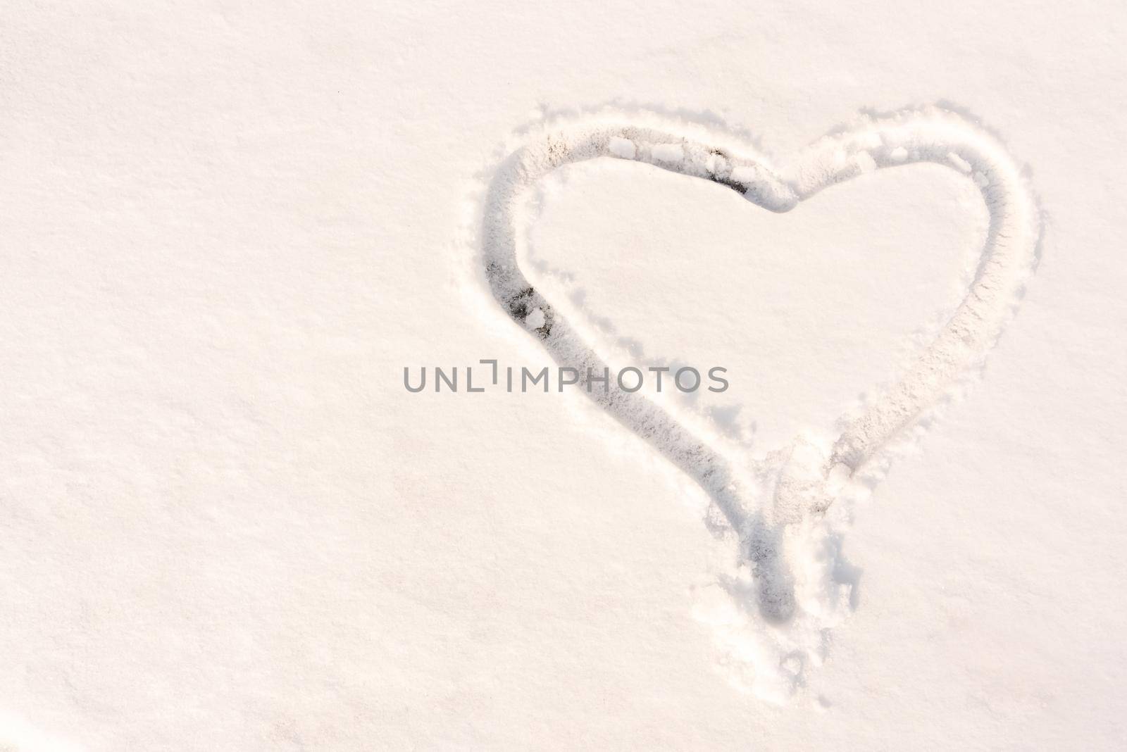 The symbol of the heart, painted on the fresh white snow with copy space.