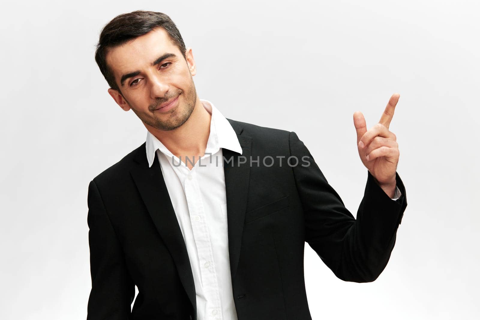 man in a modern suit showing index finger up emotion self-confidence official isolated background by SHOTPRIME