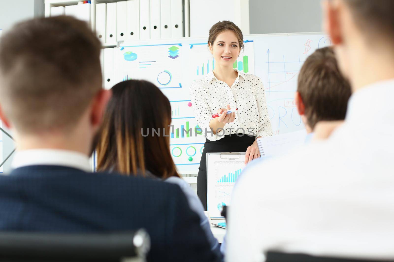 Portrait of businesswoman explain and show plan for future company development, board with goals, general meeting. Business, strategy, teamwork concept
