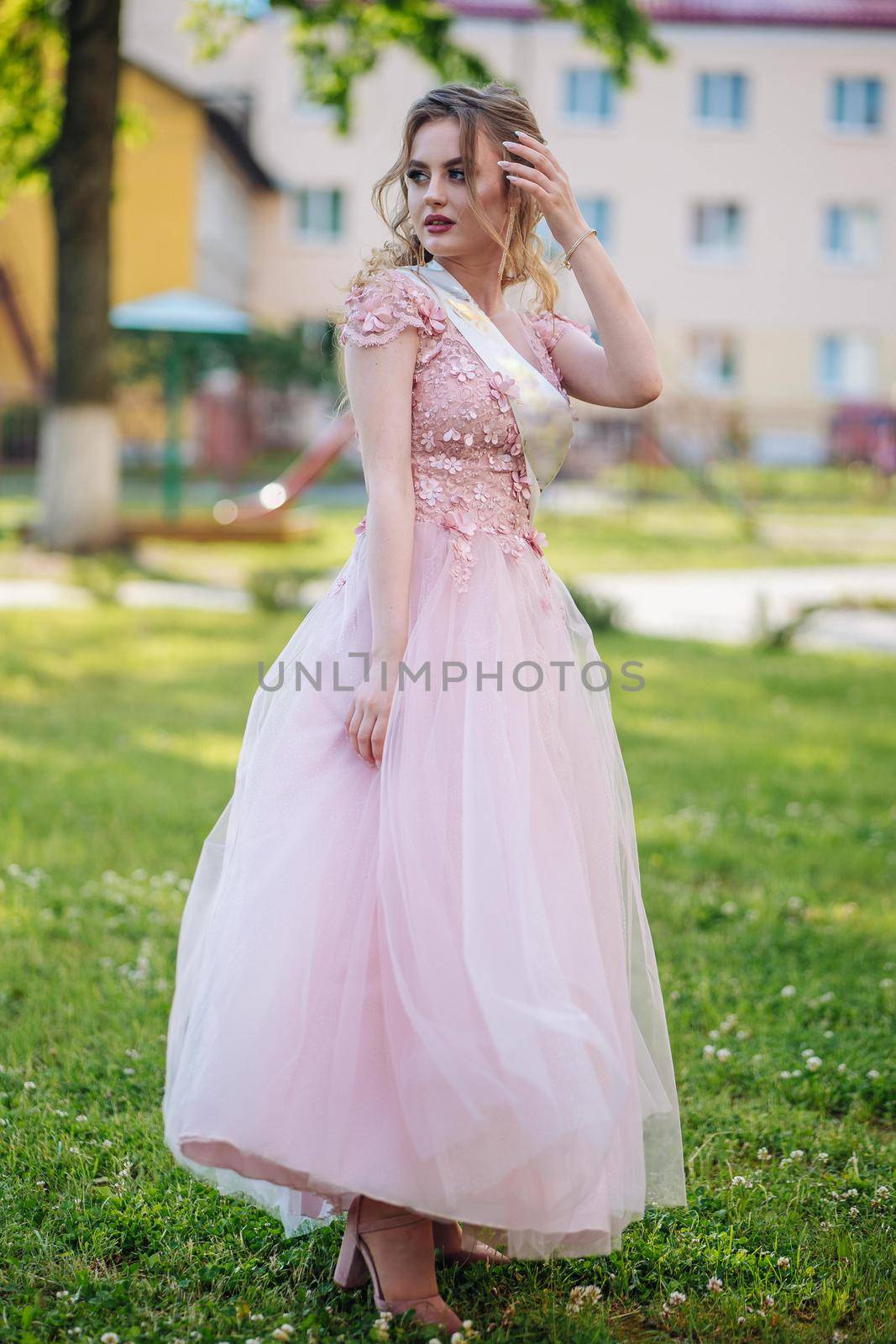 Beautiful schoolgirl in dress at the prom at school. by DovidPro