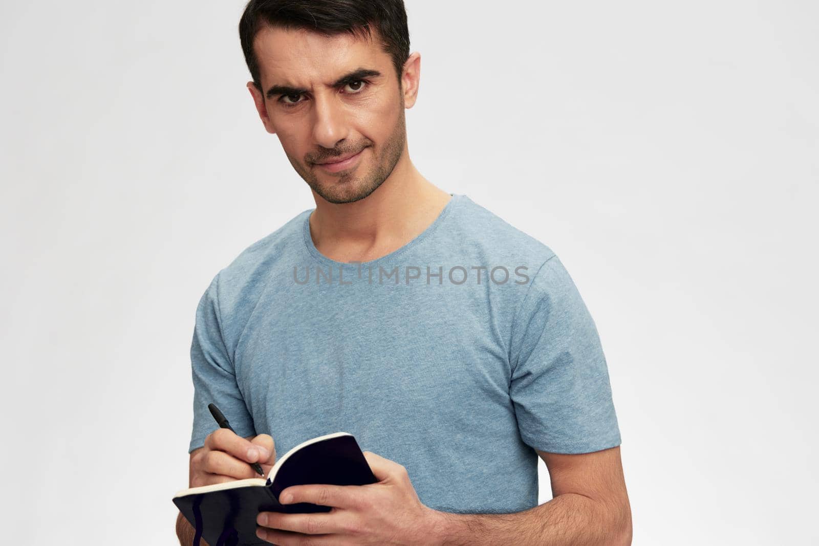 portrait man writes in a notebook t-shirt glasses lifestyle cropped view by SHOTPRIME