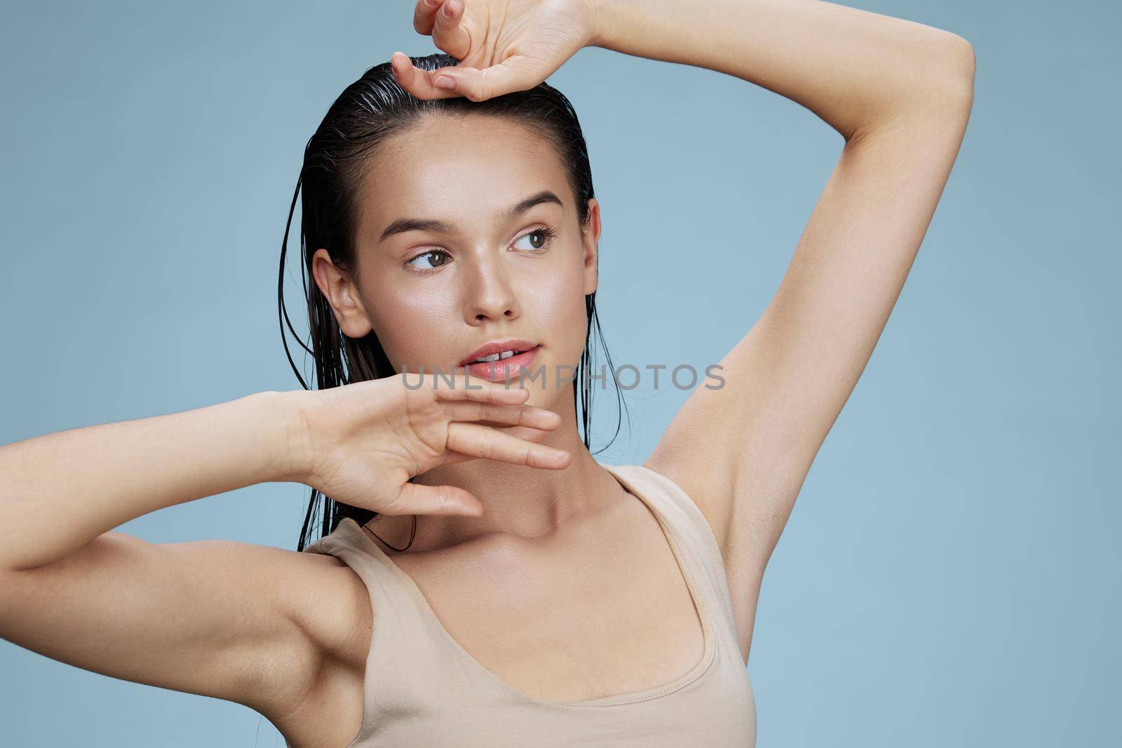 brunette touches the face skin care charm posing studio blue background. High quality photo