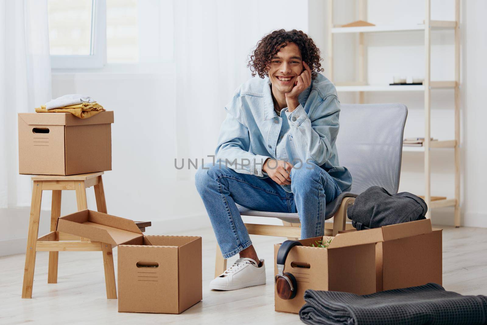 handsome guy cardboard boxes in the room unpacking interior. High quality photo